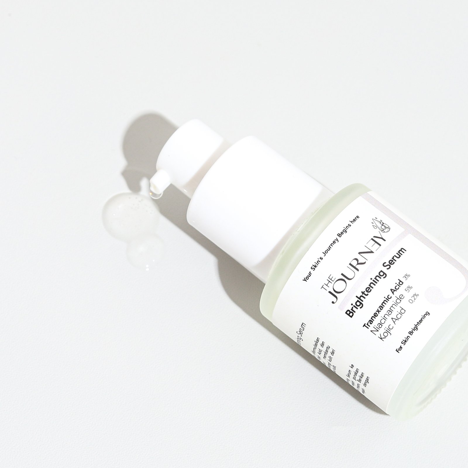 Brightening serum dengan kandungan Niacinamide 5%, Tranexamic Acid 3%, dan Kojic Acid 0.2%, dikemas dalam botol kaca dengan pipet.
