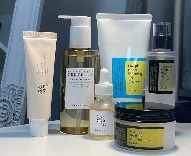Produk skincare tertata di meja rias, terdiri dari pembersih, serum, dan pelembap.